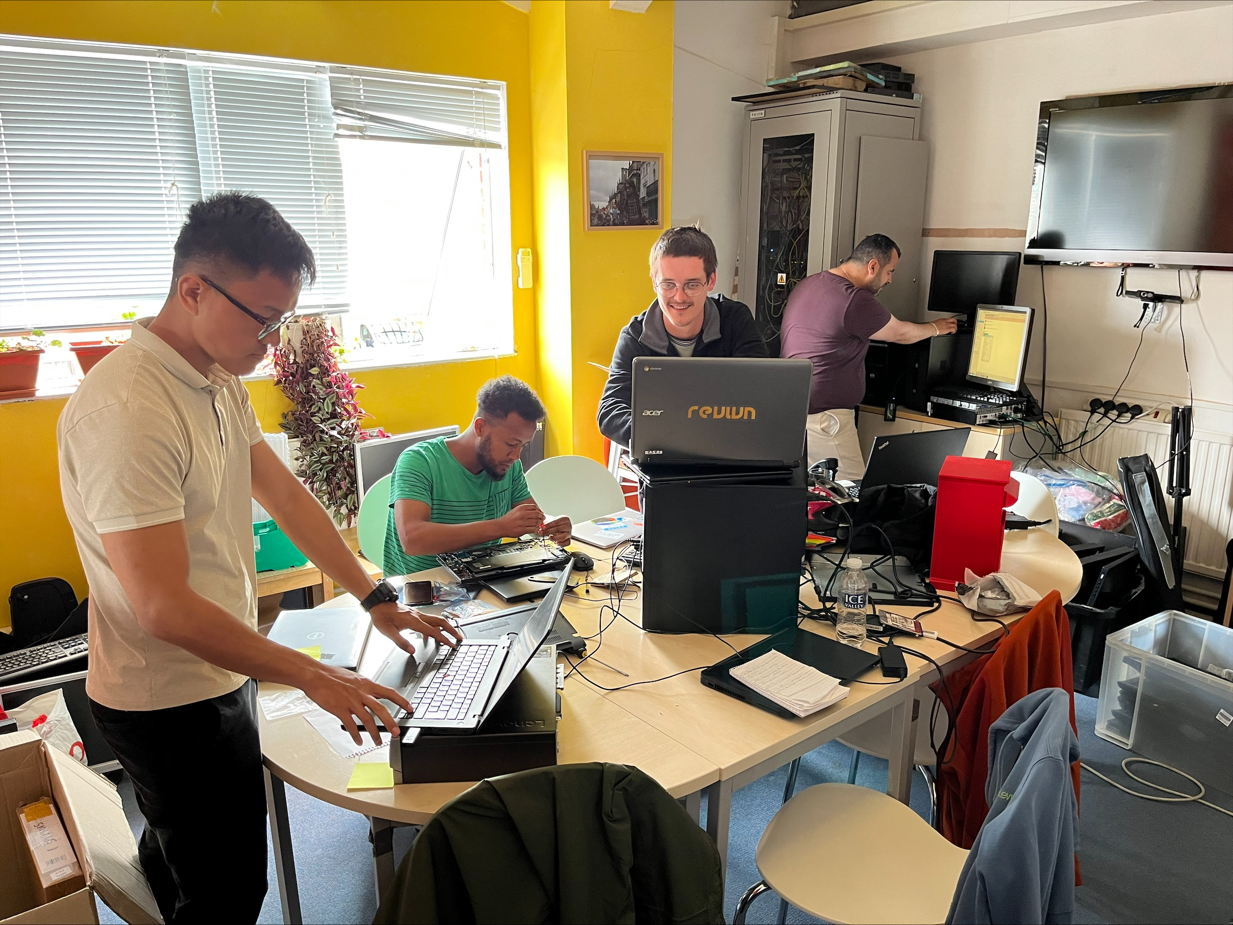 Image Asylum Welcome volunteers refurbishing laptops.