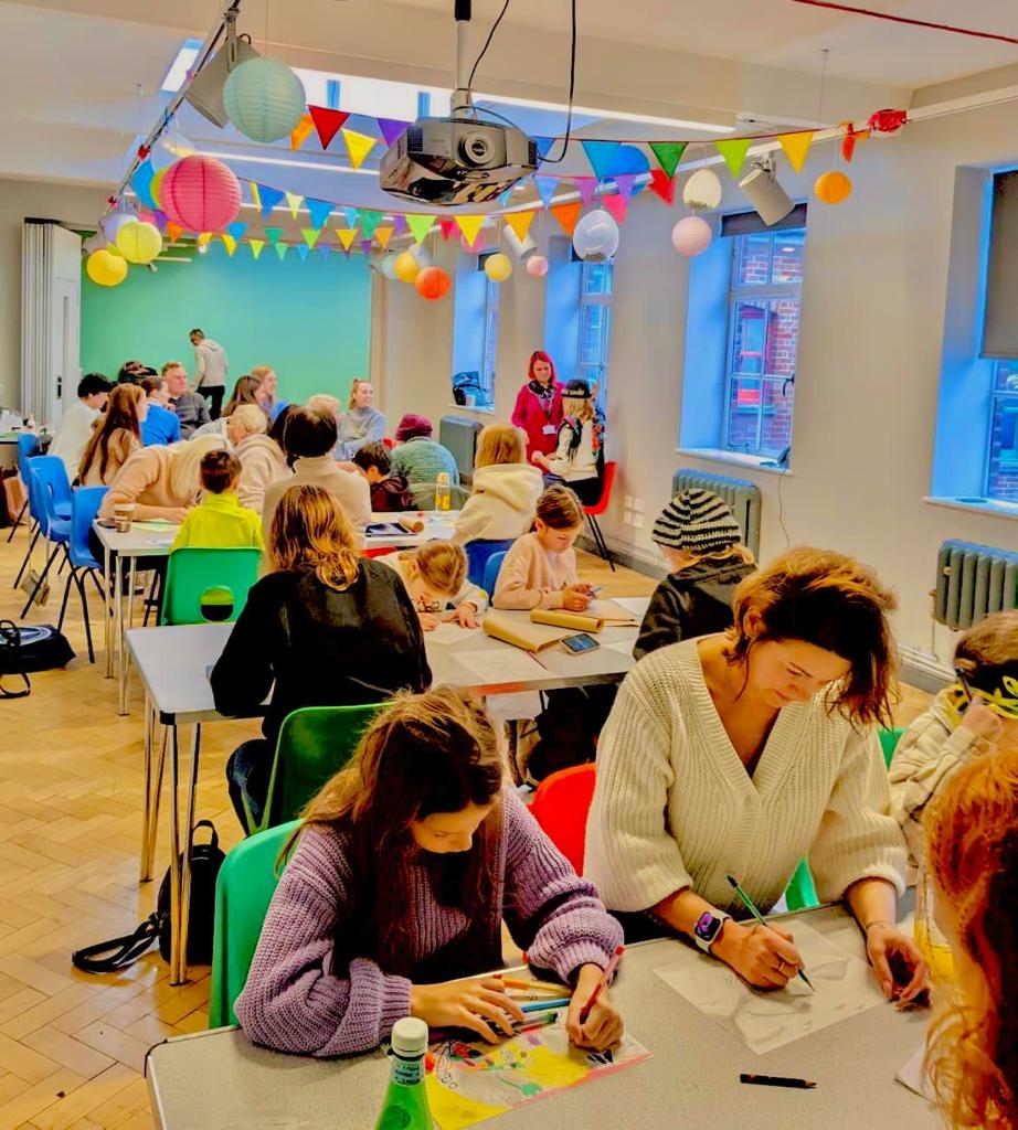 A group of people working on an art project in a relaxed and colourful environment.