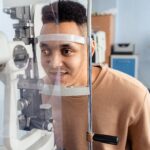 A patient having an eye test by machine (placing their chin on a rest).