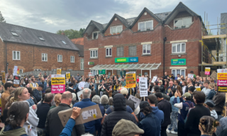 A mixed crowd of hundreds in Magdalen Road.
